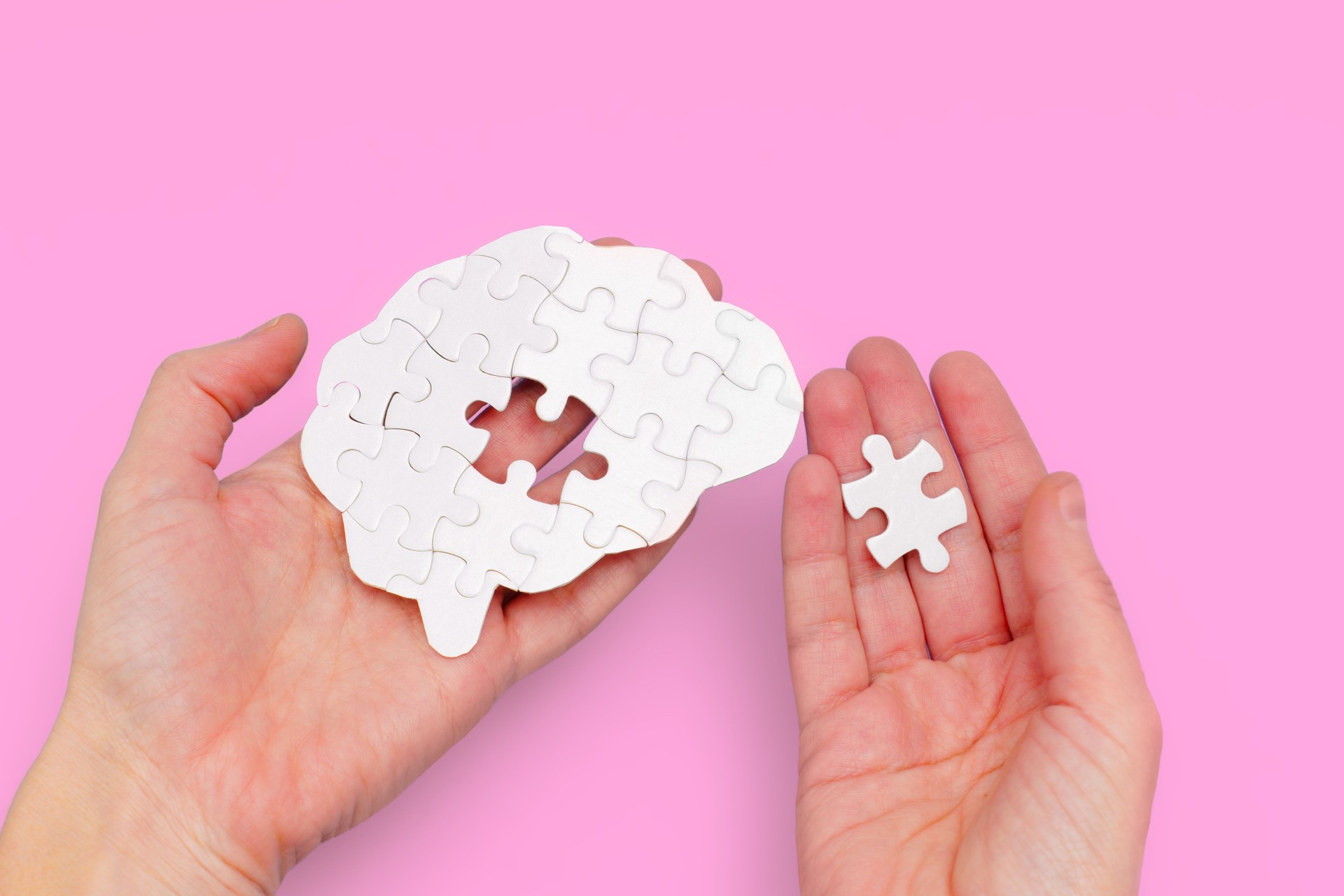 Brain Puzzle with a Missing Piece in Hands